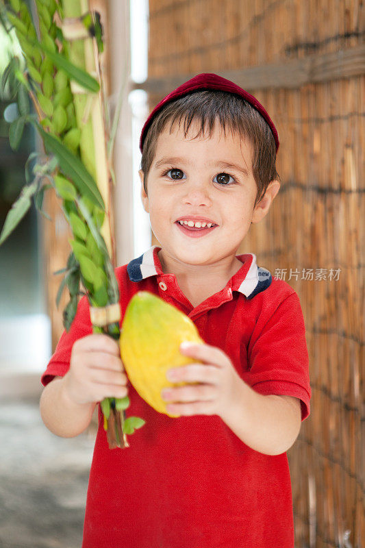 住棚的男孩拿着露露和etrog