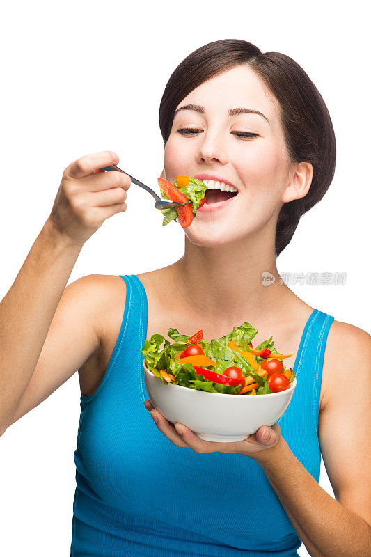 快乐的年轻女子在吃沙拉