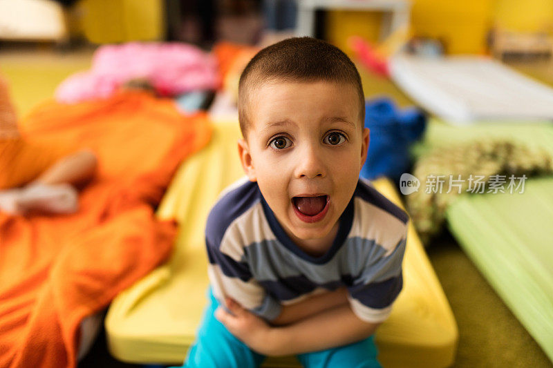 小男孩穿着睡衣盯着相机，嘴巴张着。
