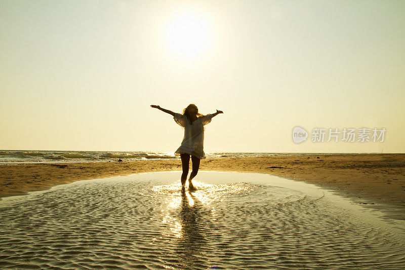 美丽的女人在海滩上跳舞