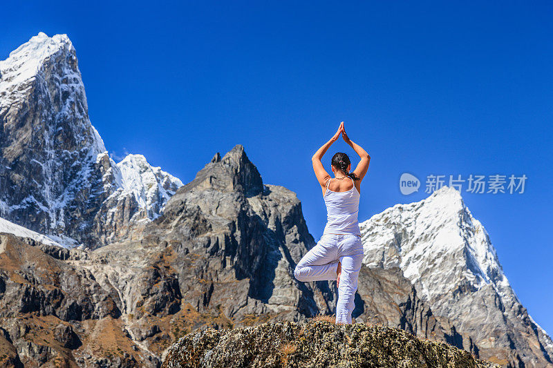 年轻女子在喜马拉雅山，珠穆朗玛峰国家公园练习瑜伽