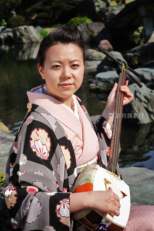 在花园里玩三味线的日本女人