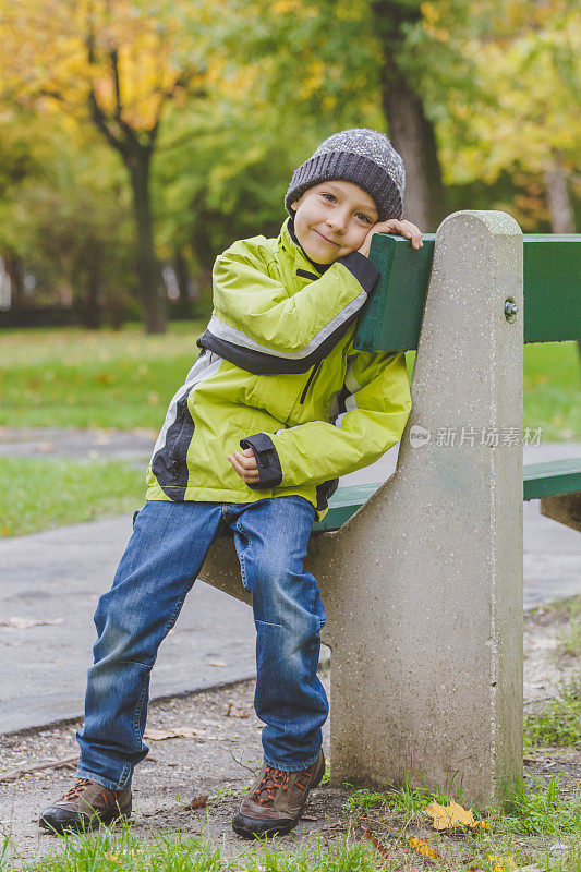 秋天，小男孩坐在长凳上