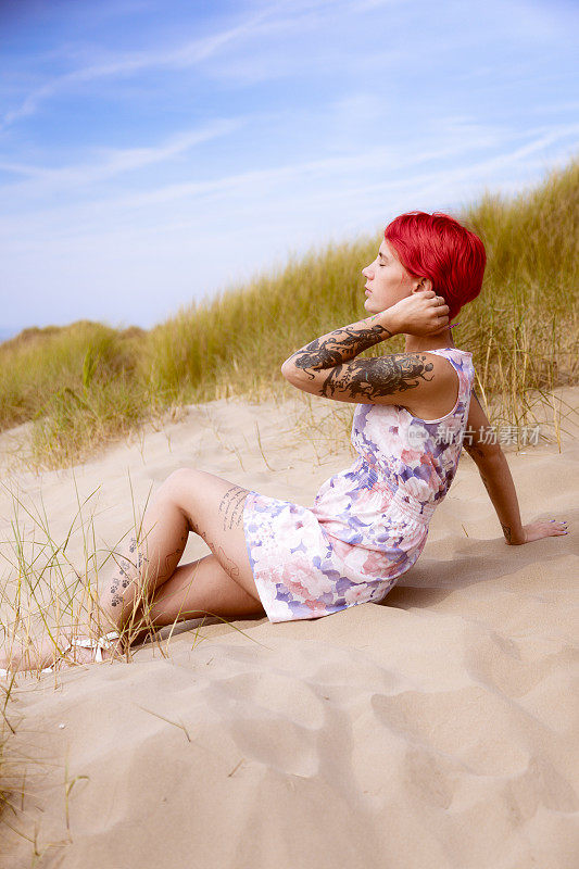 红头发的人在沙丘里晒太阳