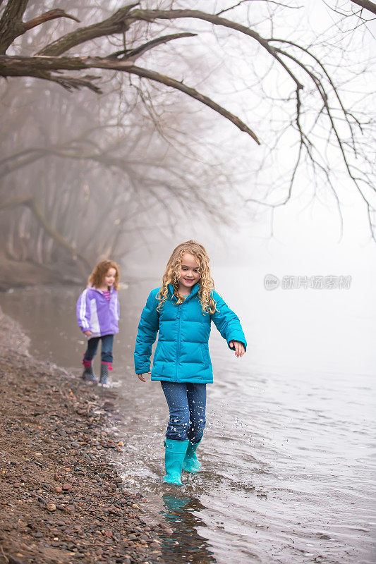 两个年轻的女孩在河边早春