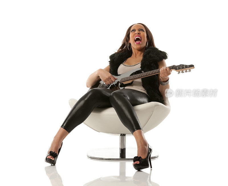 坐在椅子上弹吉他的女人