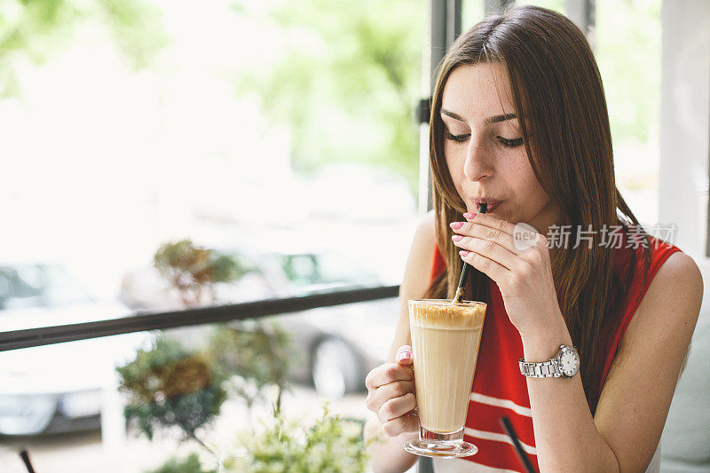 年轻女孩在咖啡厅喝咖啡