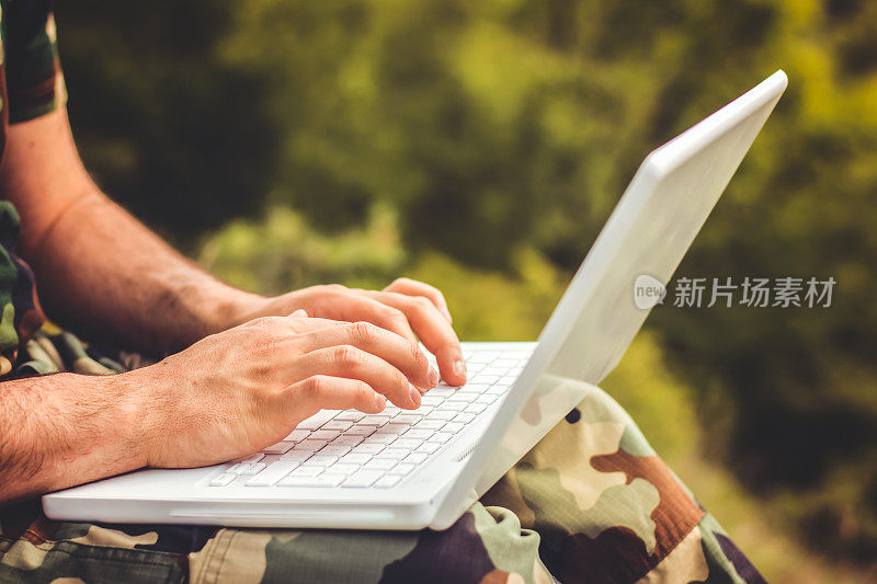 一个军人使用笔记本电脑的特写