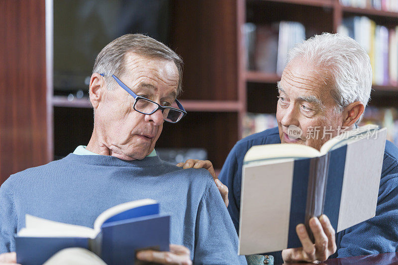 两个老人一边看书，一边聊天