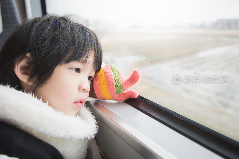 快乐的亚洲孩子看着窗外的火车