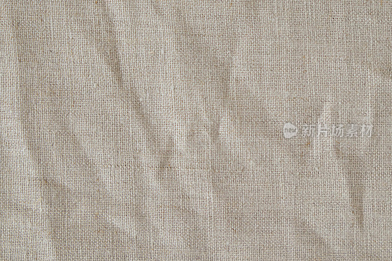 褶皱米色棉麻织物纹理背景，细节特写，质朴皱皱的复古织物。