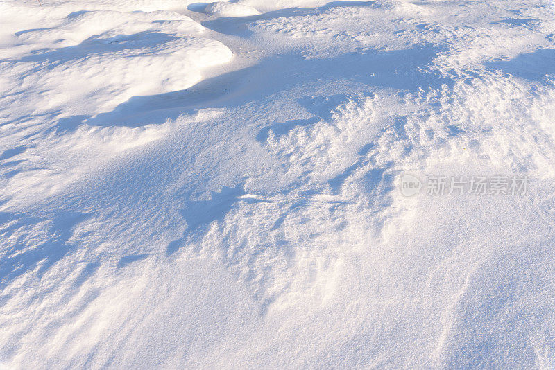 雪堆、风在雪面上雕刻出图案。