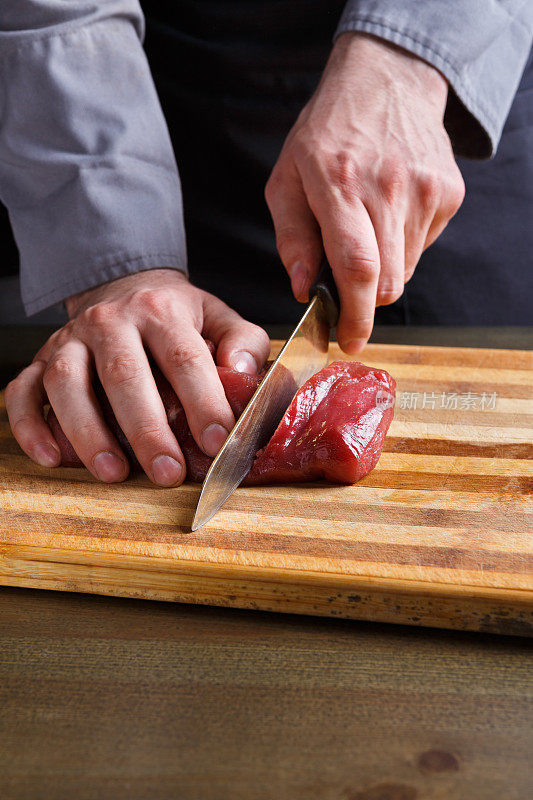 厨师在餐厅厨房的木板上切菲力牛排