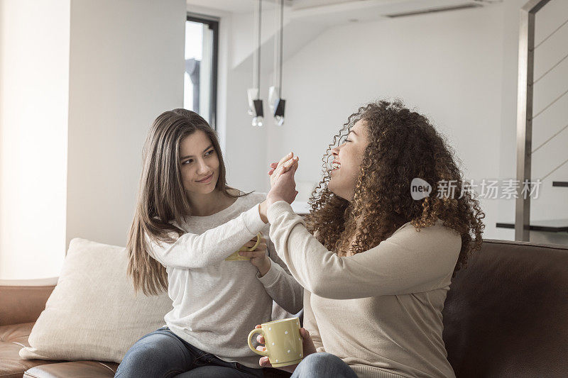 两个女人在沙发上一起喝咖啡
