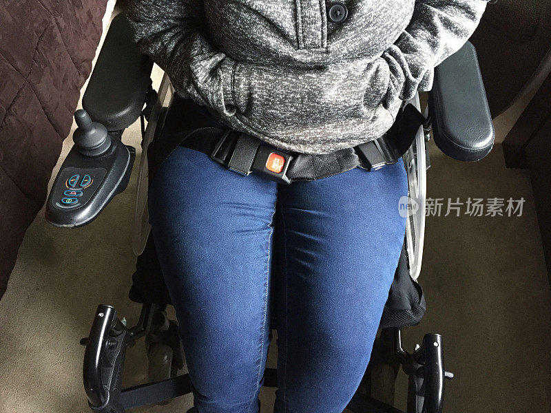 残疾女孩在电动轮椅上系安全带