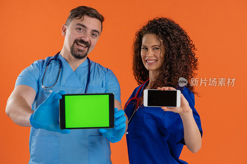 两位医生展示了带有色度键绿色屏幕的数字平板电脑和带有空白屏幕的智能手机，情绪积极