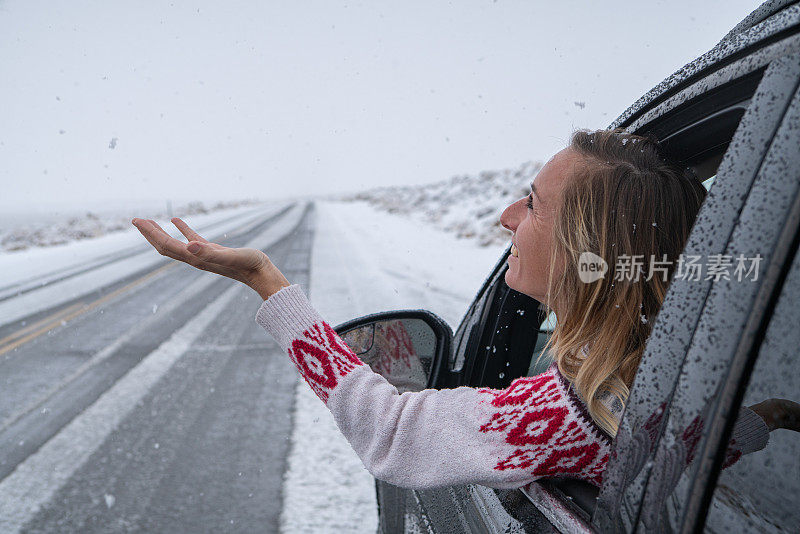 车里的女人伸手去摸雪