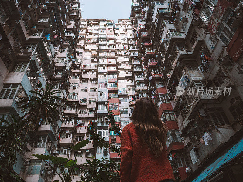 香港，一名女子抬头看着拥挤的公寓