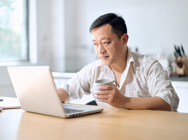 中年男子自由职业者使用笔记本电脑在线学习在家工作