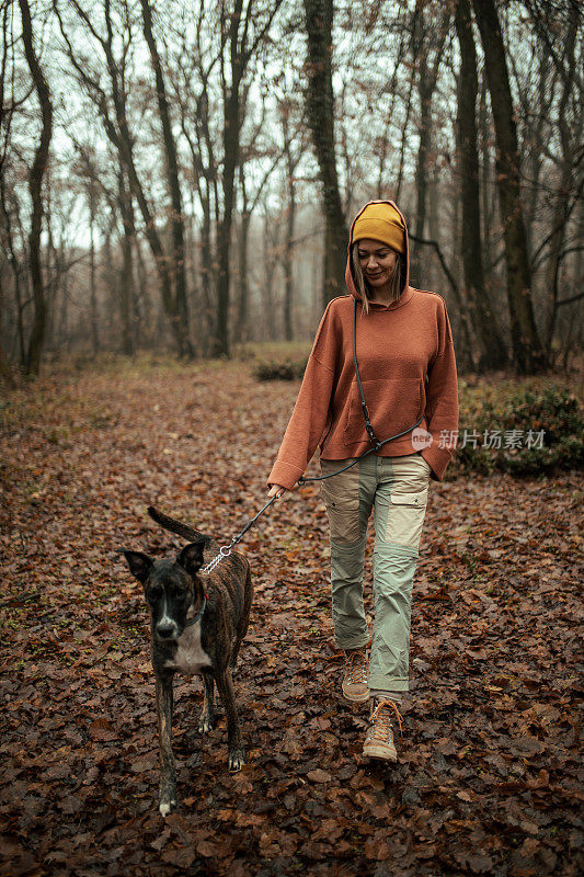 一个年轻的白人女人在遛狗