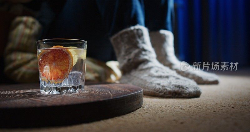 女人的脚坐在地板上，喝着注入的水