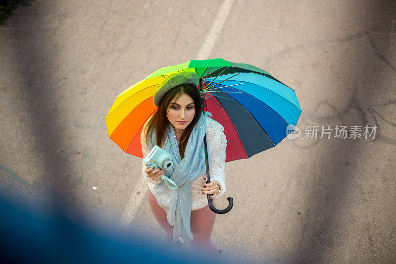 漂亮凉爽的女人带着五颜六色的雨伞在秋天的一天