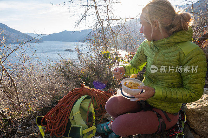 女性攀岩者用可重复使用的容器吃午餐