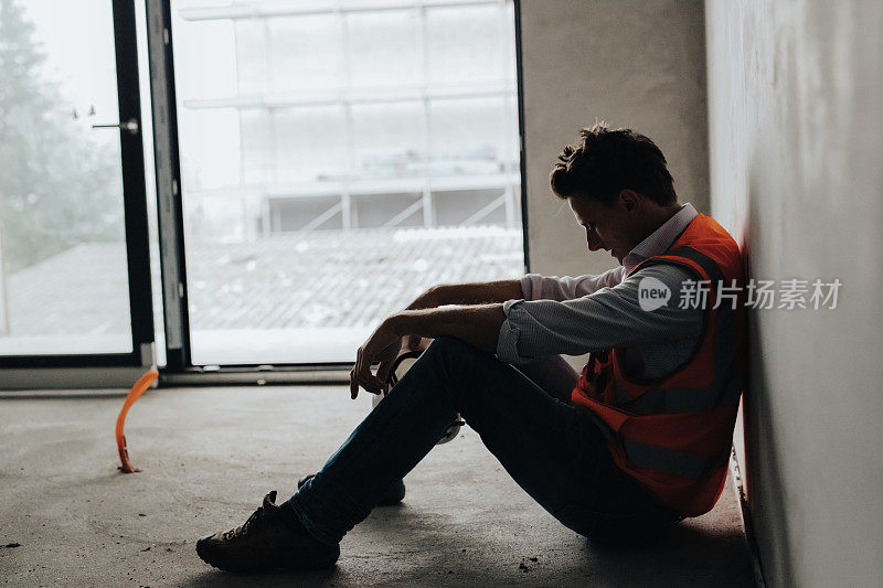 忧心忡忡的建筑承包商坐在建筑工地