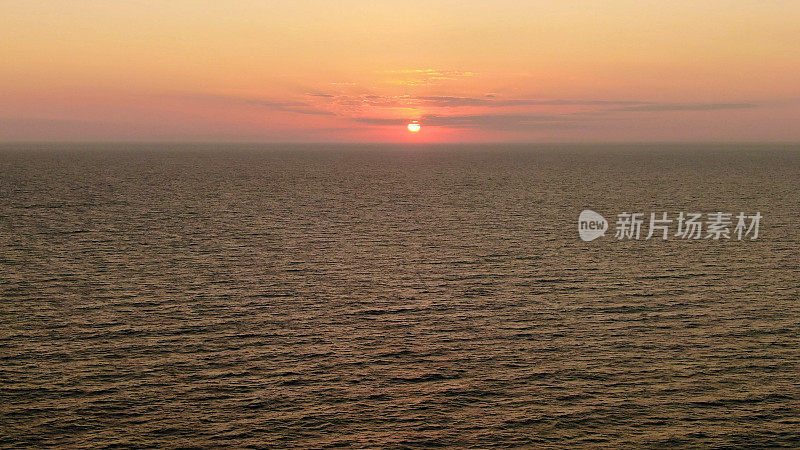 在海滩上拍摄的美丽的夏日日落。日落在海上无人机视图