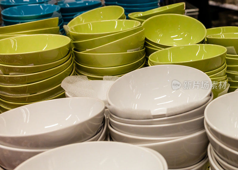 架子上排列着五颜六色的盘子和瓷碗。装饰餐具。