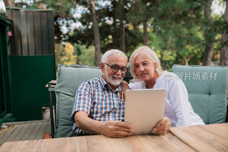 快乐的老年夫妇用数字平板电脑与家人facetime