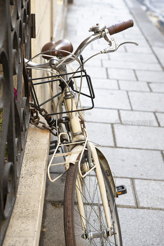 巴黎后街人行道上的栏杆上拴着自行车