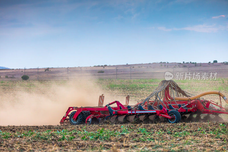 农民在拖拉机上用苗床耕作机准备土地