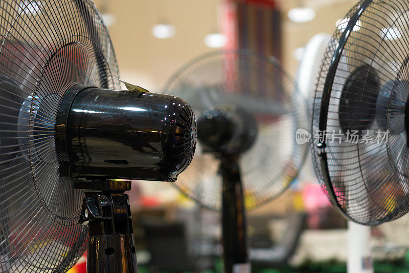 烈日炎炎的夏日，超市货架上摆放的电风扇的特写。购买节能电器，树立节能理念