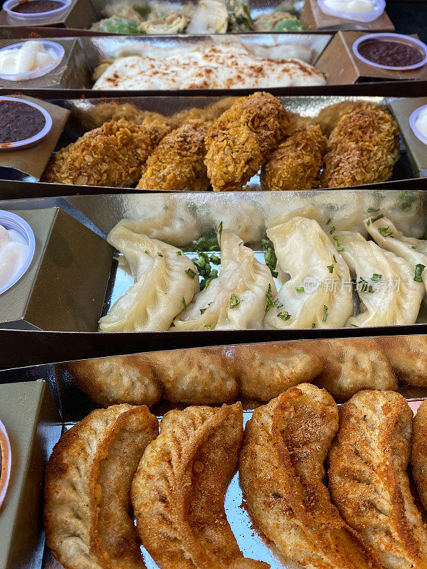 momos(饺子)，蒸炸的印度街头小吃，一次性，纸板容器，莎莎酱和蛋黄酱蘸料，一次性塑料碗，高架视图，重点在前景