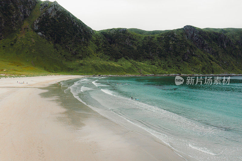 航拍的海滩与冲浪者在水晶蓝色的海在挪威