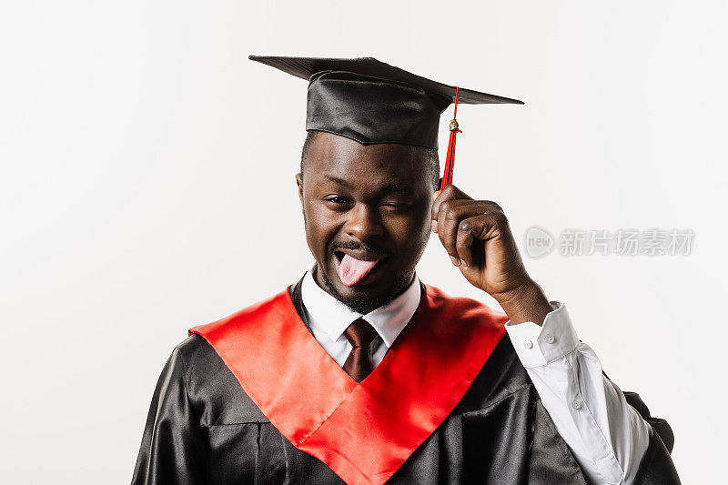 研究生肖像非洲人大学毕业并获得硕士学位。毕业典礼。快乐的非洲人在黑色毕业长袍是在白色背景扮鬼脸。