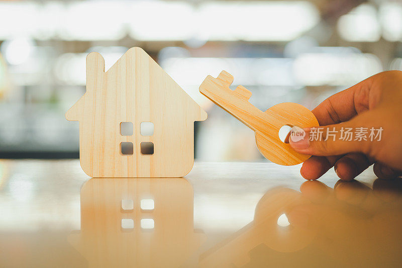 房屋模型和钥匙在房屋保险经纪代理人或推销员手中。房产中介提供房屋、财产保险和保障、经济适用房等概念