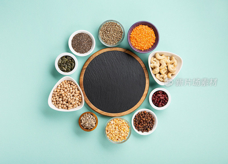 健康干豌豆蛋白粉和植物性蛋白质食品(豆类，扁豆，豆类，种子)蓝绿色背景。