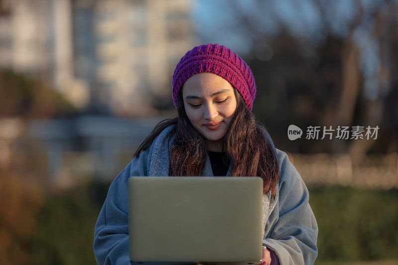 年轻的学生女孩正在外面学习。