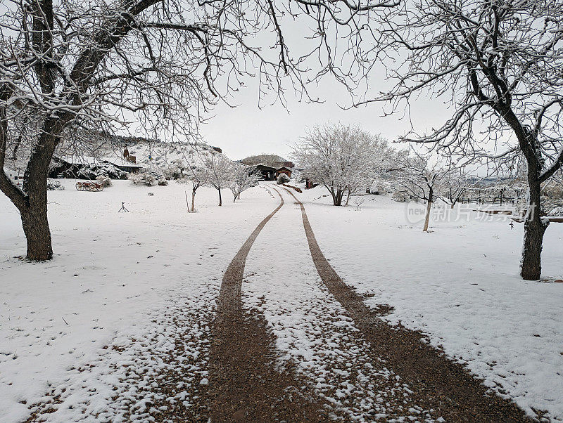 犹他州洛克维尔大雪后的牧场房屋和乡村小路，背景是南梅萨