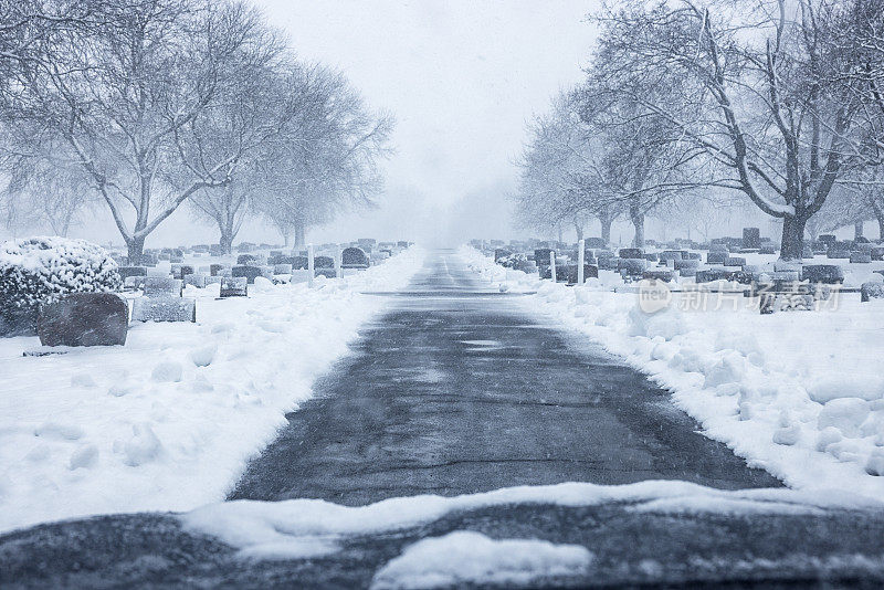 在墓地路上行驶在死寂的冬季暴风雪