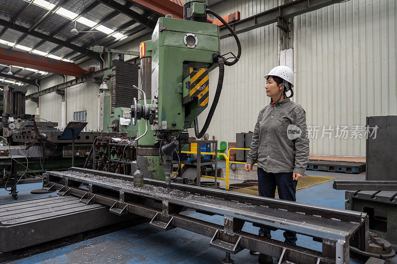 一位亚洲女工在一家机械厂工作