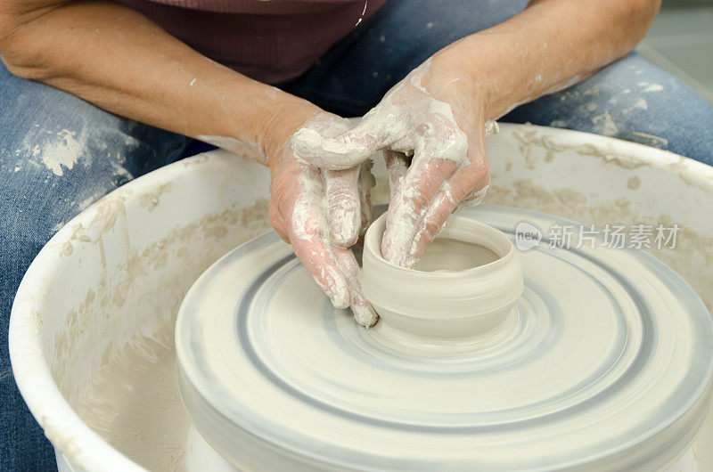 手在陶轮上塑造粘土