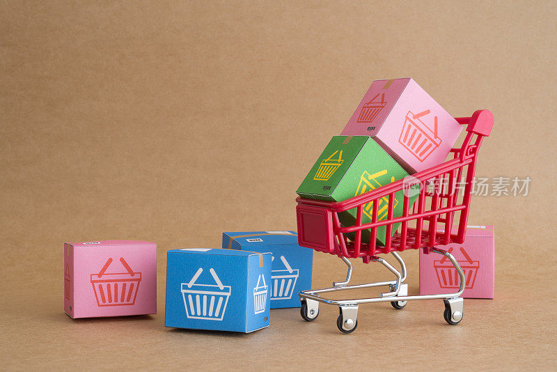 彩色包裹纸箱与购物车或购物车的购物篮标志。
