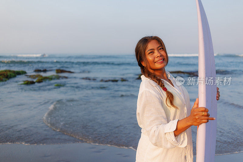 印度尼西亚女冲浪者与她的冲浪板的特写肖像