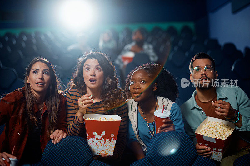 一群多种族的朋友在电影院看悬疑电影。