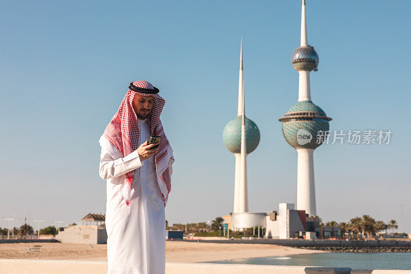 身穿传统服装的科威特年轻人在户外玩手机
