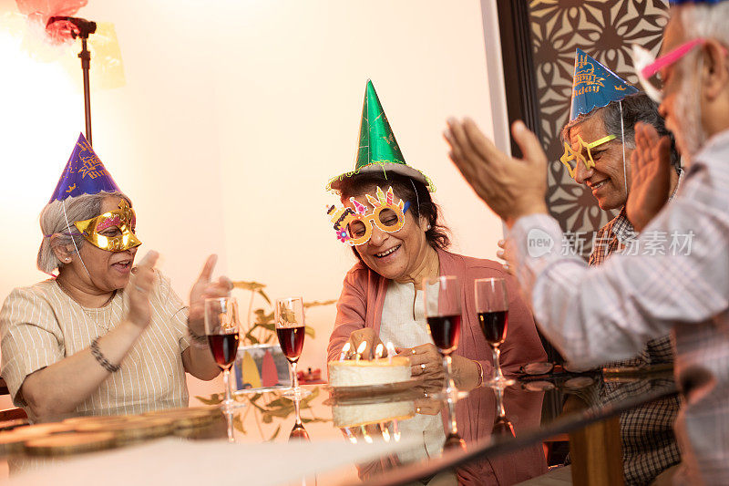 老妇人在家里和朋友庆祝生日