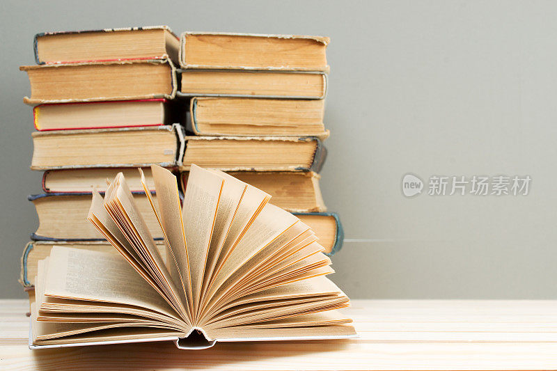 打开书，在木桌上堆叠精装书。